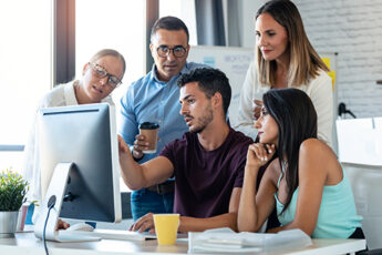 Team of website design Ocean County creators looking at a monitor
