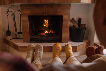 Family's socked feet in front of Freehold fireplace
